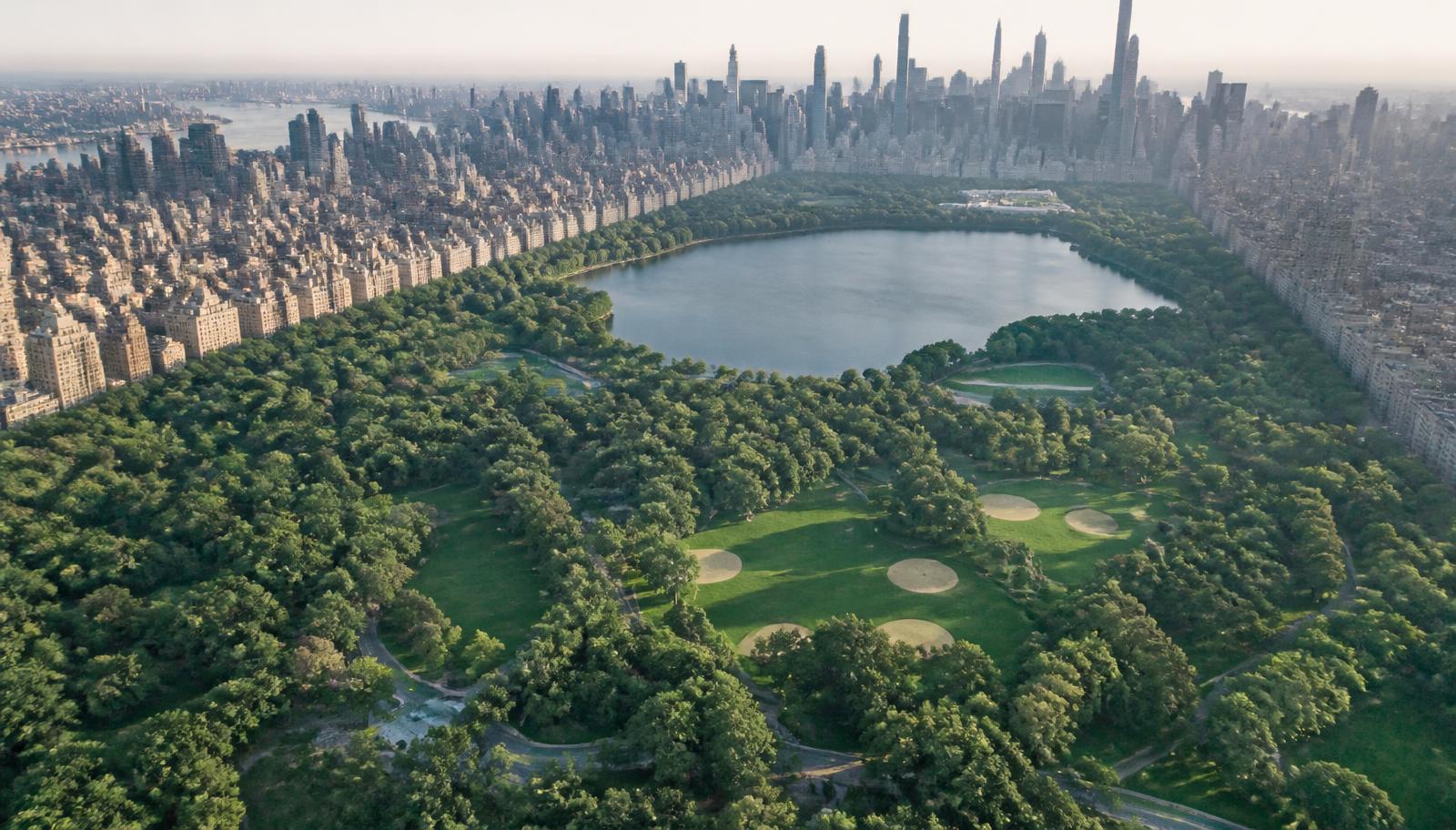 Vista aérea de um grande parque urbano cercado por prédios da cidade